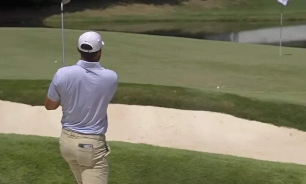 Mira cómo el golpe «bunker» de Scottie Scheffler bounce rebota en un aspersor y acaba rodando hacia el agua